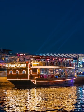 Dubai Canal evening cruise with illuminated boat and city lights.