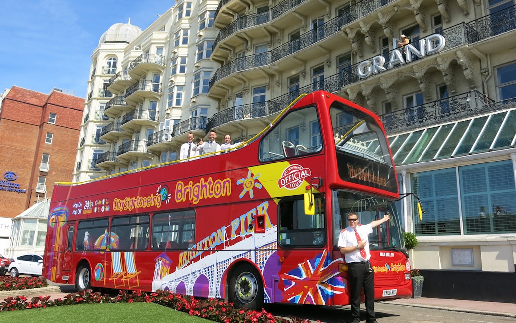 Brighton hop-on hop-off bus in front of the Grand Hotel with tour guide.