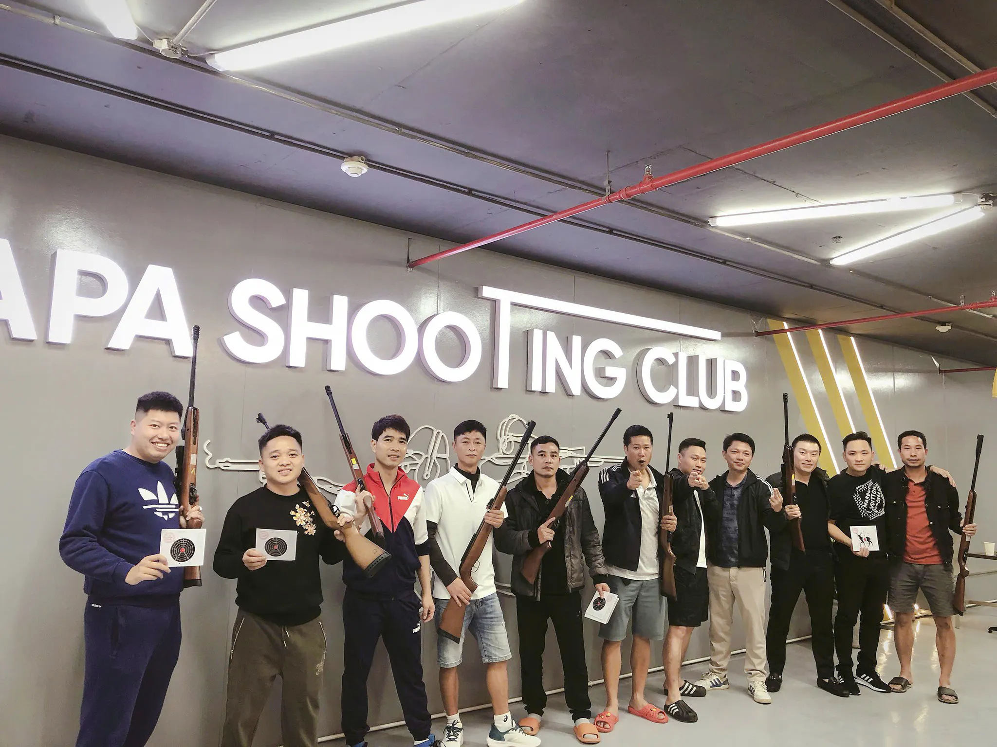 Group at Sa Pa Shooting Club holding rifles and targets, guided shooting experience.