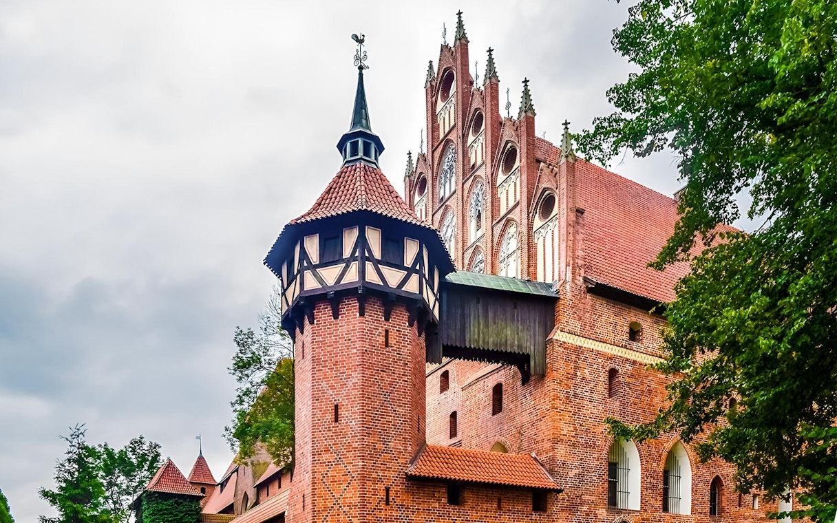 Malbork Castle's Gothic architecture with red brick towers, viewed on a tour from Gdańsk.
