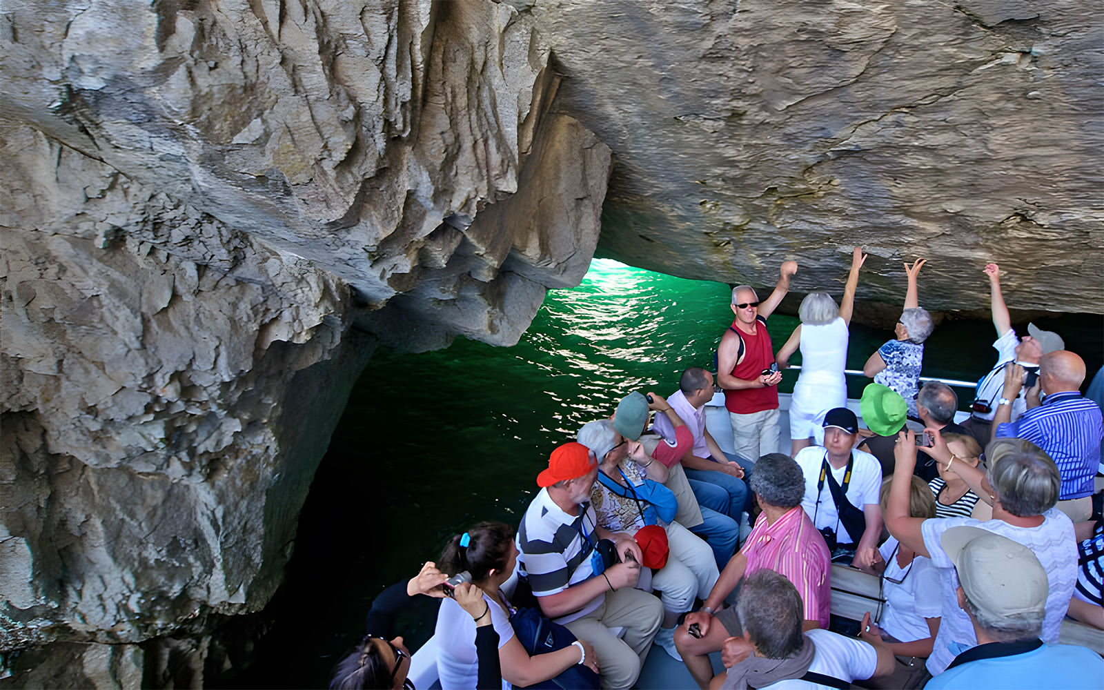 Tourists on a boat exploring a sea cave in Capri, Italy.