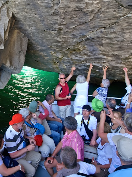 Tourists on a boat exploring a sea cave in Capri, Italy.