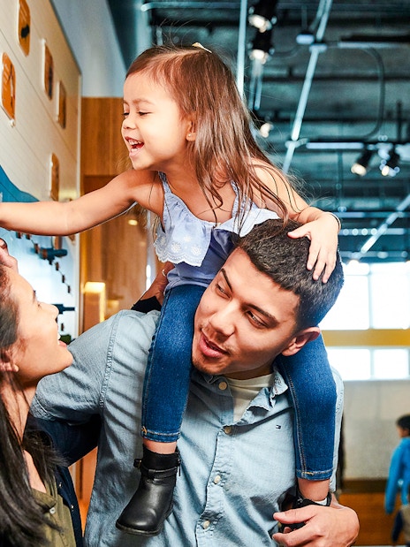 Family exploring interactive exhibit at Museum of Science Hall of Human Life.