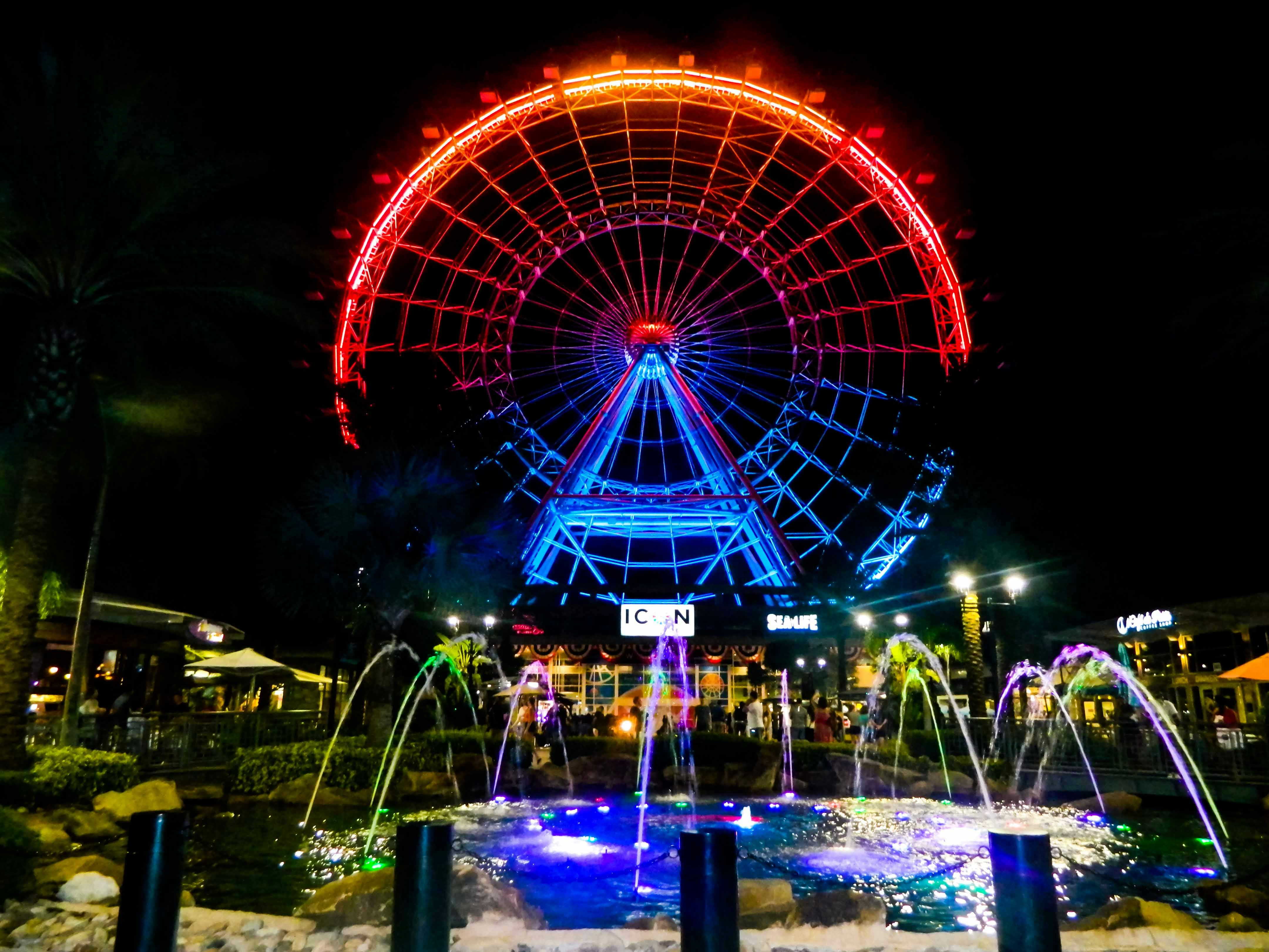 Ferris wheel illuminated at night with colorful lights at Icon Park, Orlando.