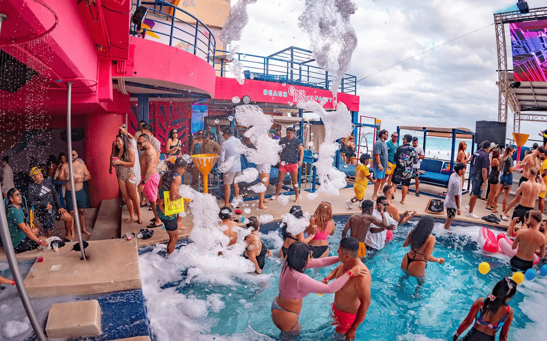 People enjoying a lively foam party at Coco Bongo Beach Party.