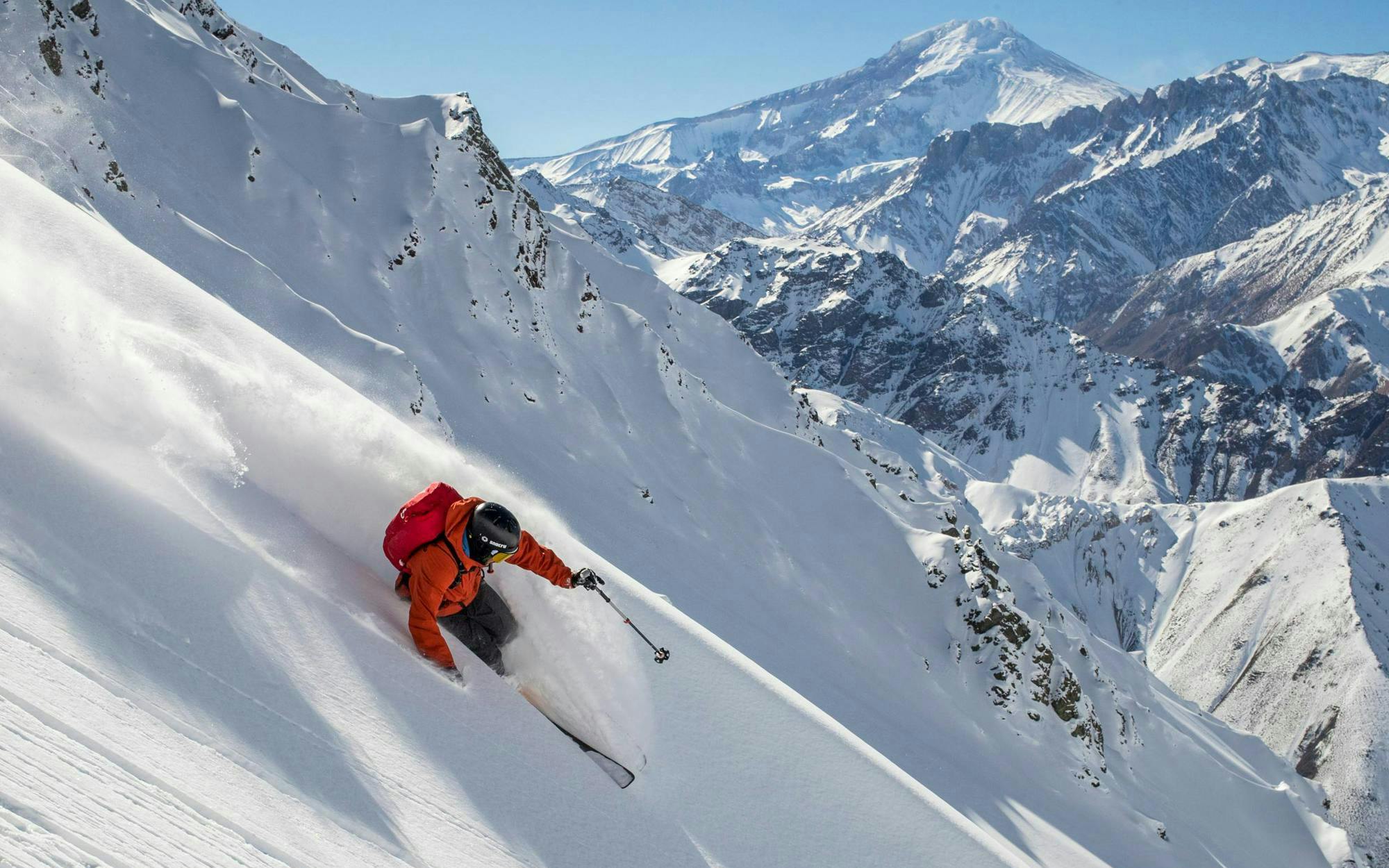 Skier navigating steep snowy slope at Valle Nevado ski resort, Chile.
