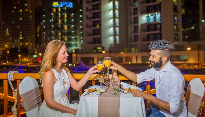 Couple dining on Alexandra VIP Dhow Cruise in Dubai Marina.