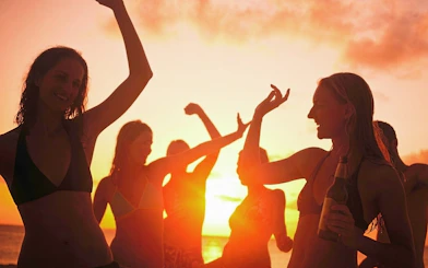 Tourists dancing at sunset on a boat party in Cartagena's Bay.