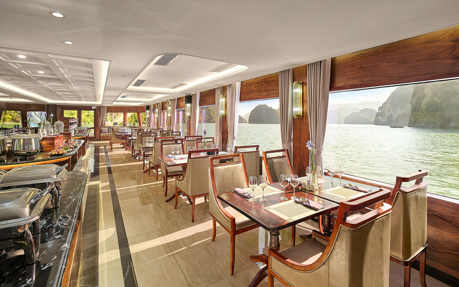 Dining area on Ha Long Bay 5-Star Cruise with sea view through large windows.