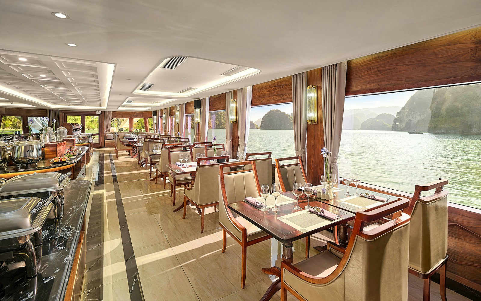 Dining area on Ha Long Bay 5-Star Cruise with sea view through large windows.