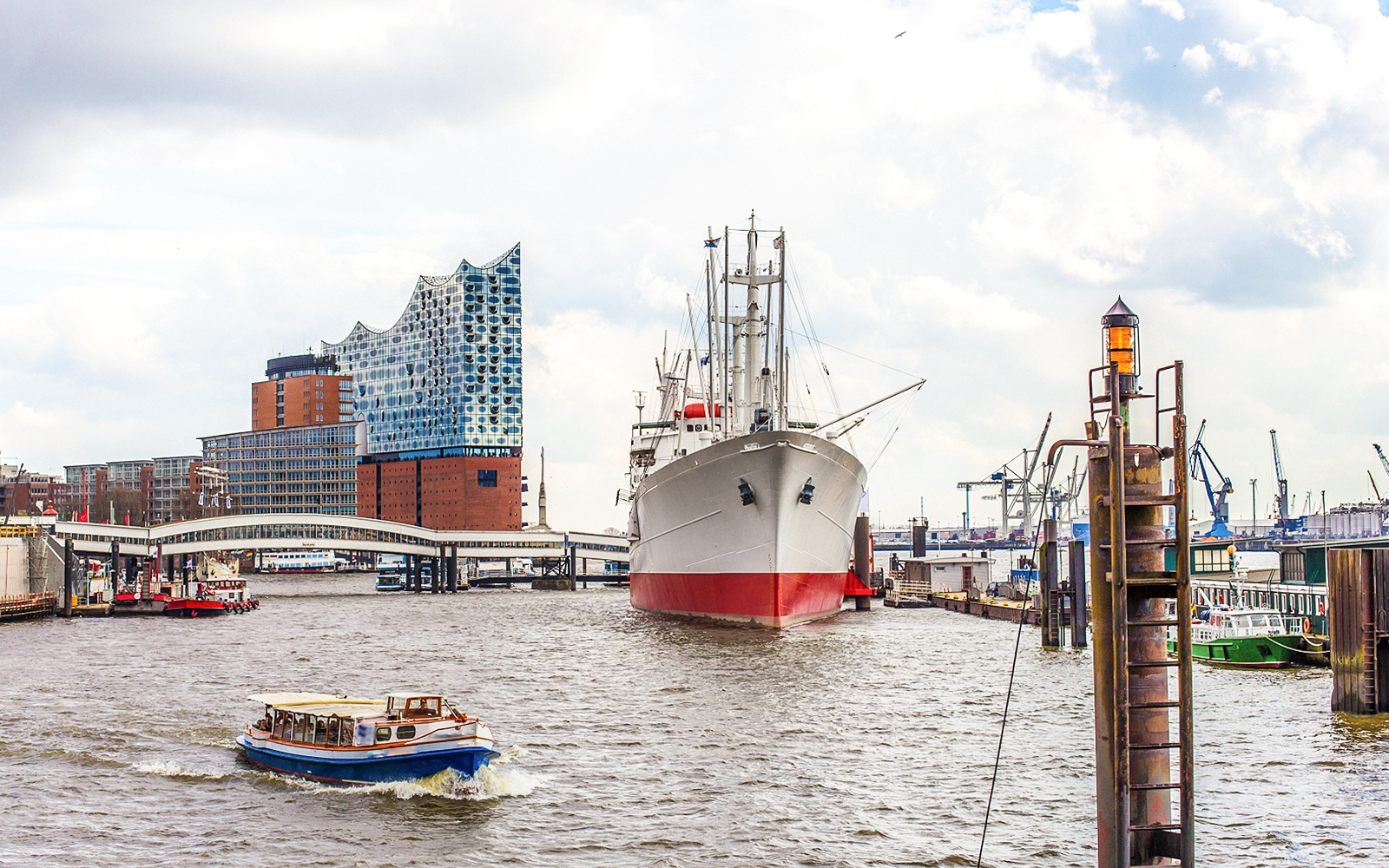 Boat passing Elbphilharmonie and ship in Hamburg Harbor during 2-hour boat tour.