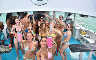 Adults enjoying a party boat cruise with drinks and music in Punta Cana.