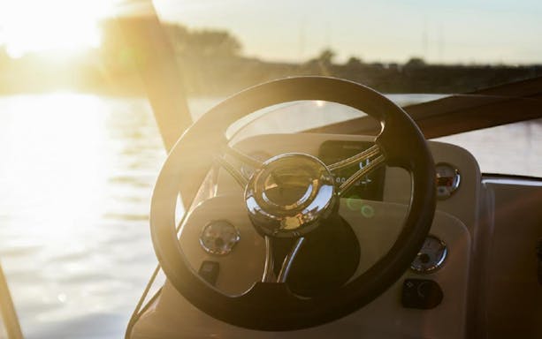 Boat steering wheel on Vistula River cruise in Krakow at sunset.