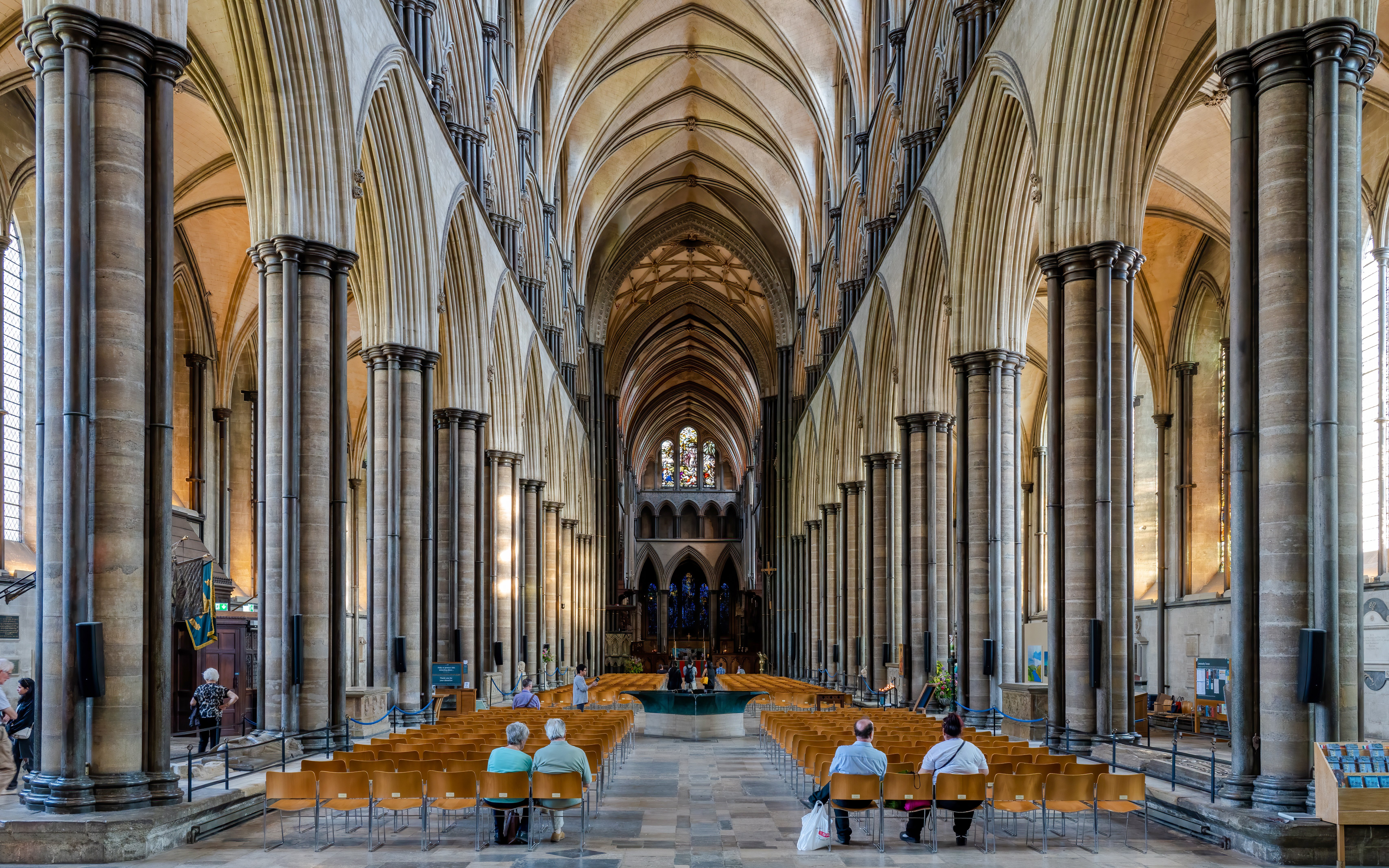 Salisbury Cathedral nave with vaulted ceilings and stained glass windows.