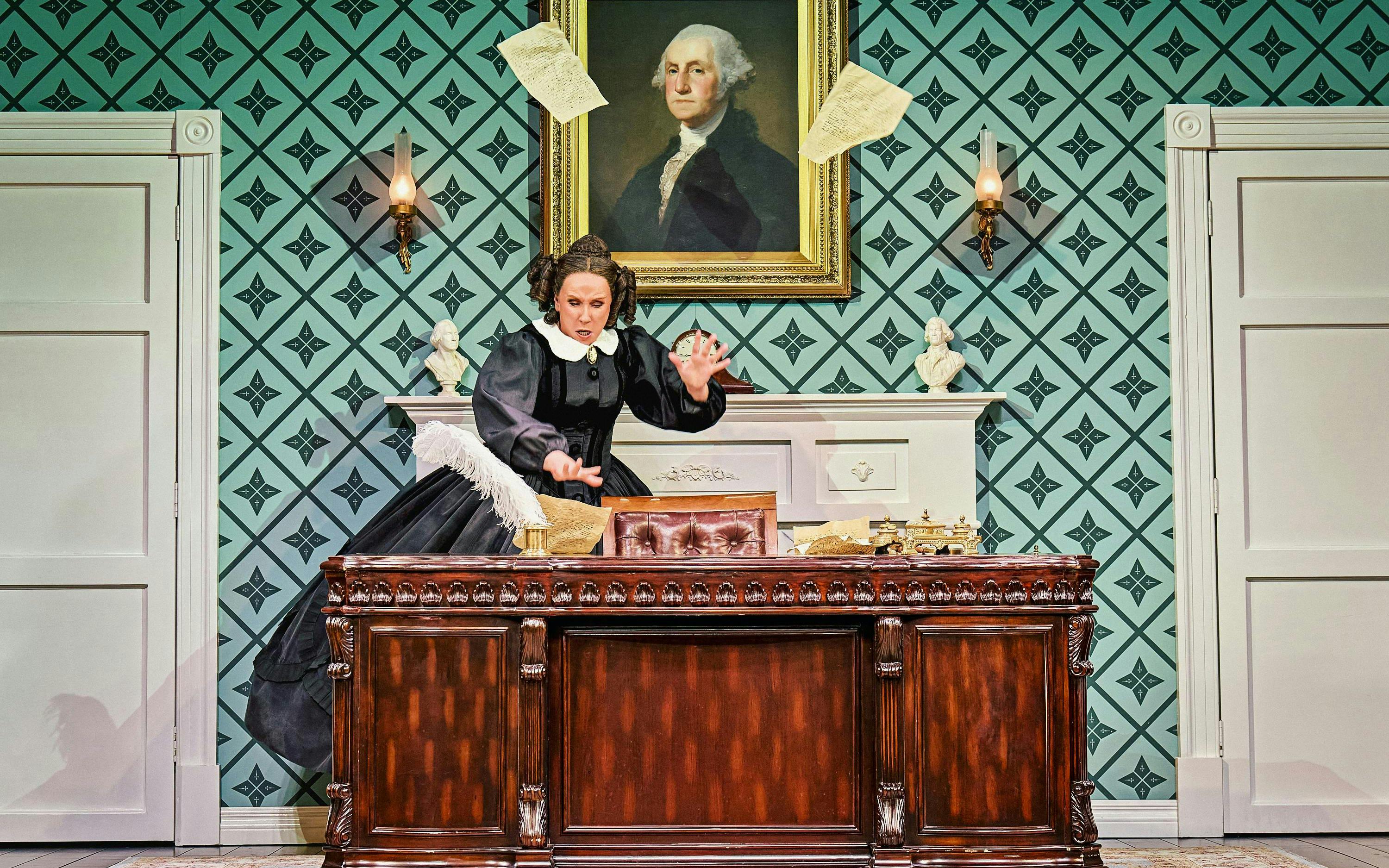 Stage scene from Oh, Mary Westend show with actor at desk, papers flying.