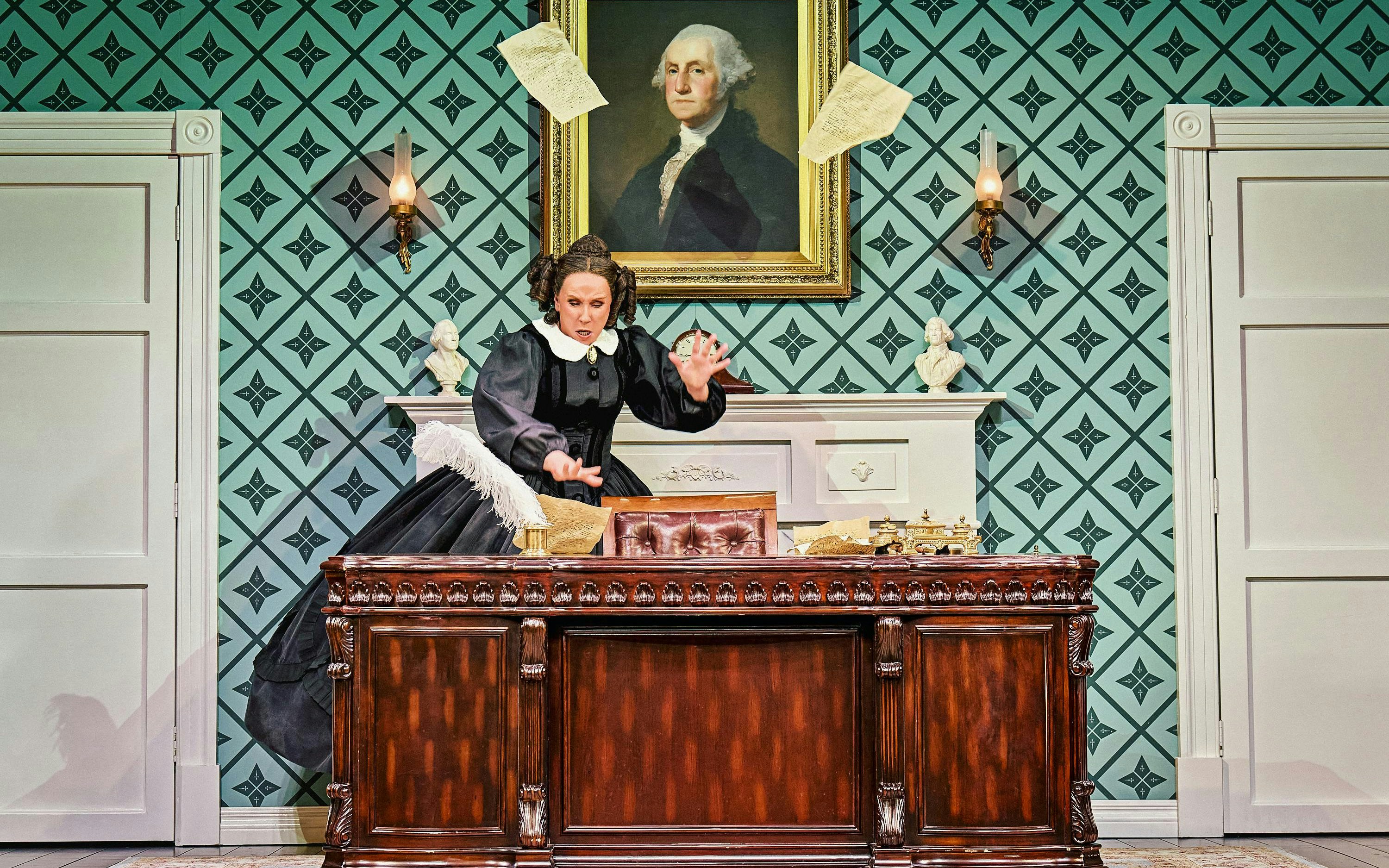 Stage scene from Oh, Mary Westend show with actor at desk, papers flying.