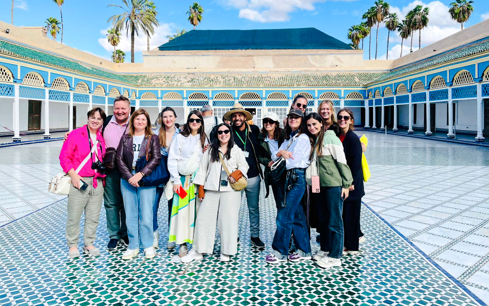 Tourists with guide at Bahia Palace courtyard in Marrakech, Morocco.