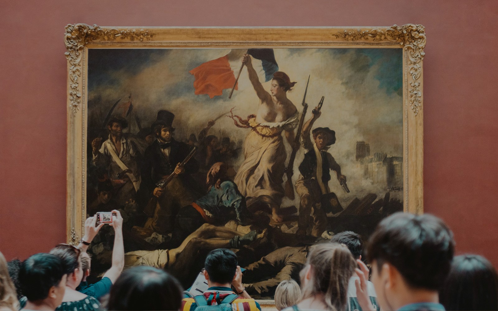 Visitors viewing Eugène Delacroix's "Liberty Leading the People" at the Louvre Museum, Paris.