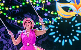 Performer in colorful costume during nighttime show at PortAventura Park.