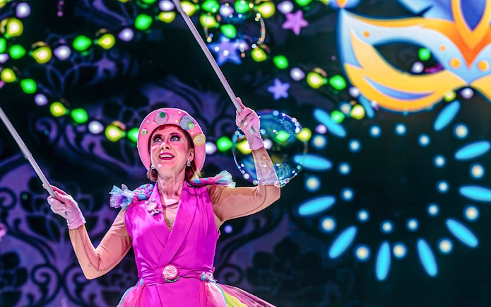 Performer in colorful costume during nighttime show at PortAventura Park.