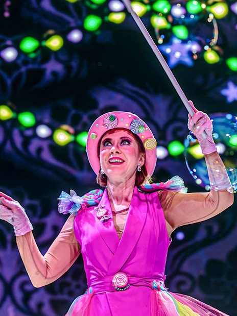 Performer in colorful costume during nighttime show at PortAventura Park.