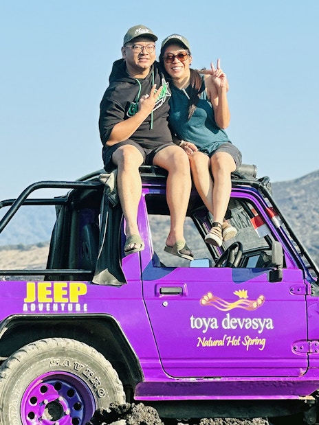 Couple sitting on a purple jeep on Mount Batur, Bali.