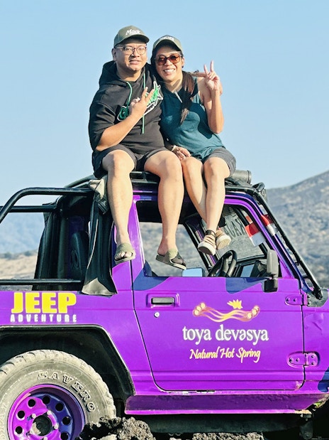 Couple sitting on a purple jeep on Mount Batur, Bali.