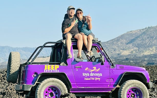 Couple sitting on a purple jeep on Mount Batur, Bali.