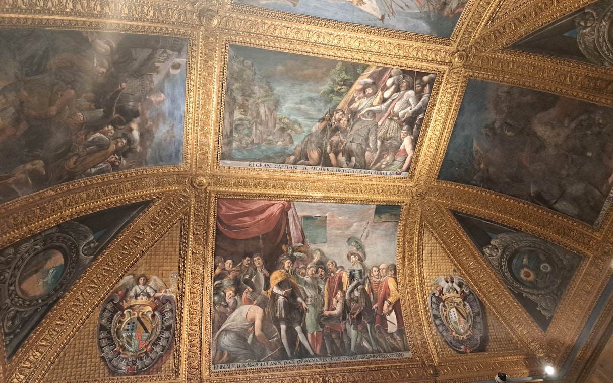 Ceiling frescoes and ornate gold detailing inside the Royal Palace of Naples.