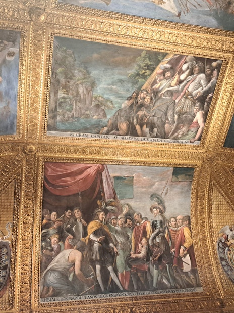 Ceiling frescoes and ornate gold detailing inside the Royal Palace of Naples.