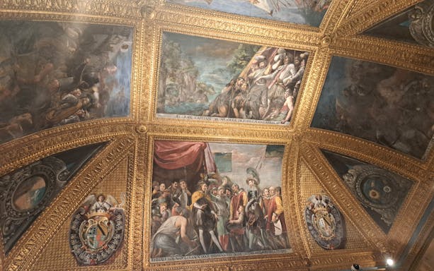Ceiling frescoes and ornate gold detailing inside the Royal Palace of Naples.