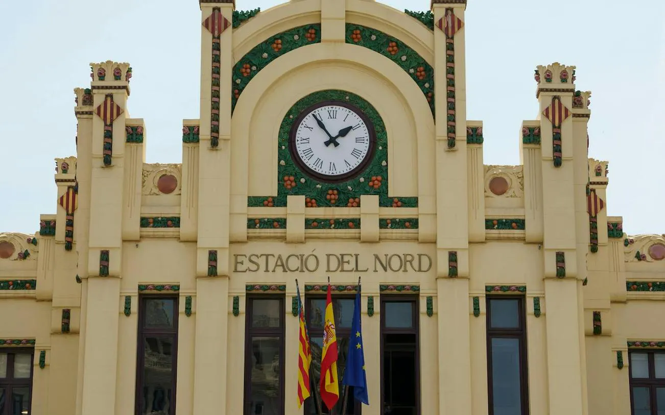 Estació del Nord facade with clock and flags, Valencia Old Town.