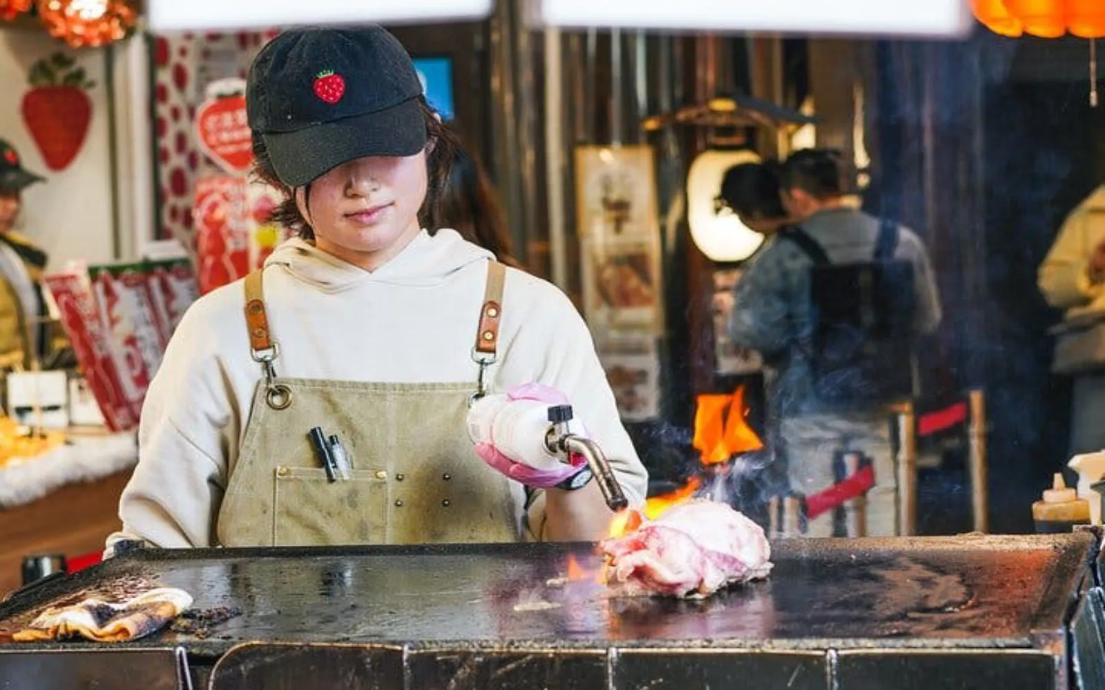 Vendor cooking food with a blowtorch at Tsukiji market, Tokyo.