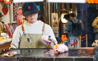 Vendor cooking food with a blowtorch at Tsukiji market, Tokyo.