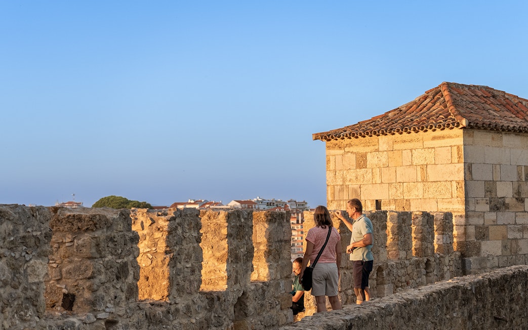Visitors exploring the ancient walls of St George's Castle in Lisbon.