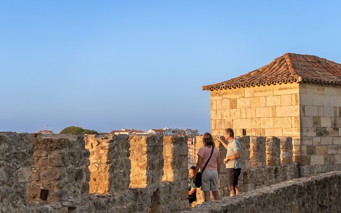 Visitors exploring the ancient walls of St George's Castle in Lisbon.