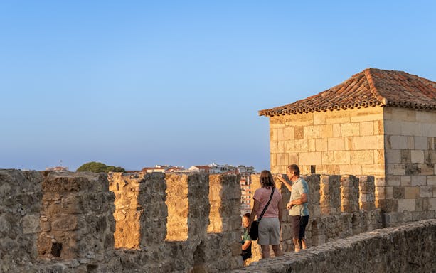 Visitors exploring the ancient walls of St George's Castle in Lisbon.