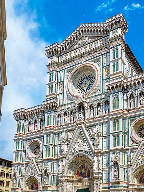 Facade of Florence Cathedral with intricate marble design and rose window.