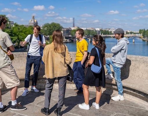 Guided tour group exploring Notre Dame islands in Paris with a view of the cathedral.