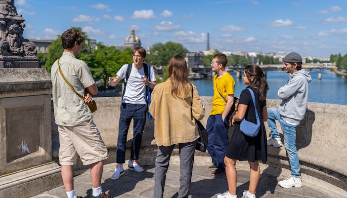 Notre Dame de Paris facade with tourists on outdoor walking tour, includes Cathedral's Crypt entry.