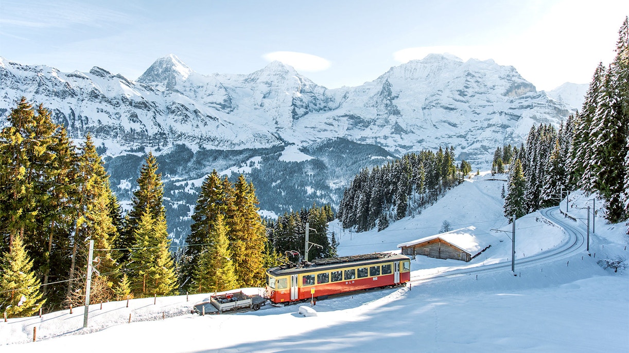 Train journey through snow-capped Swiss Alps from Interlaken to Jungfraujoch.