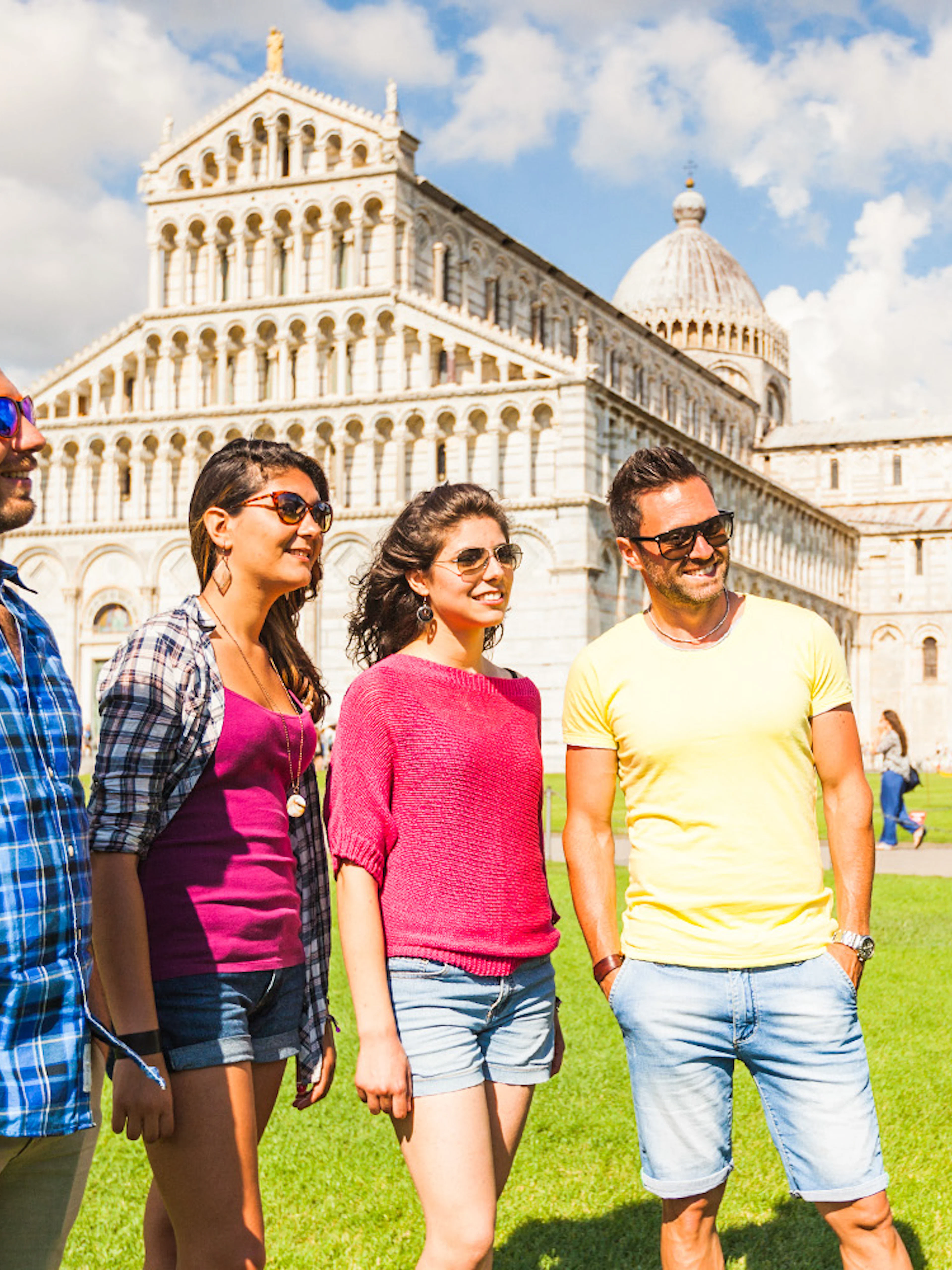 Tour group with guide in front of Pisa Cathedral and Baptistery, Italy.
