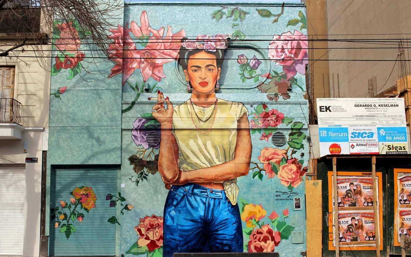 Graffiti mural of a woman surrounded by flowers on a building wall in Buenos Aires.