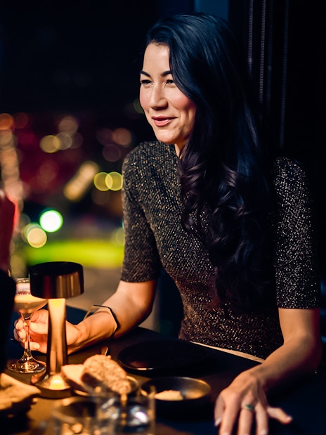 Couple dining at Melbourne Skydeck with city lights in the background.