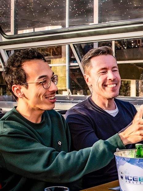 People enjoying drinks on an Amsterdam canal cruise.