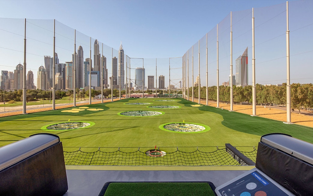 Topgolf Dubai driving range with city skyline in the background.