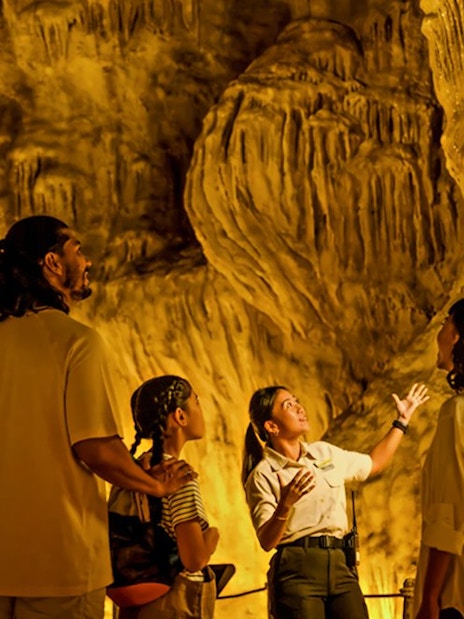 Family exploring The Cavern in Rainforest Wild ASIA with a guide.