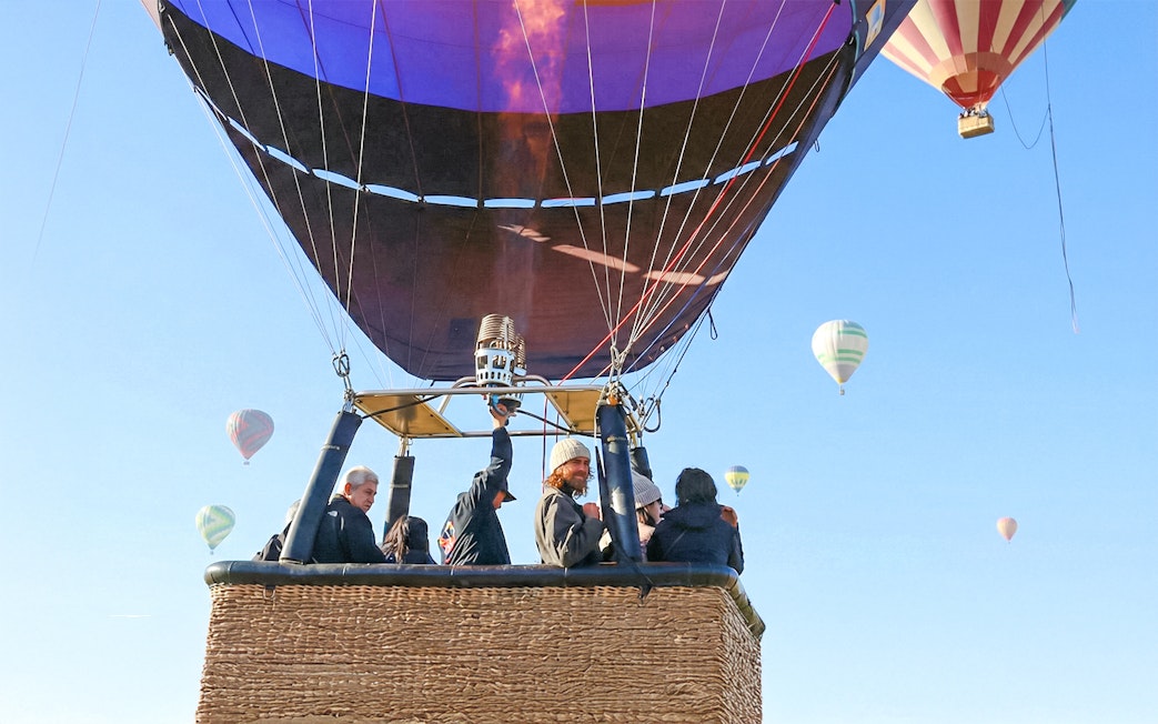 Hot air balloon flight over Teotihuacán with passengers in basket.