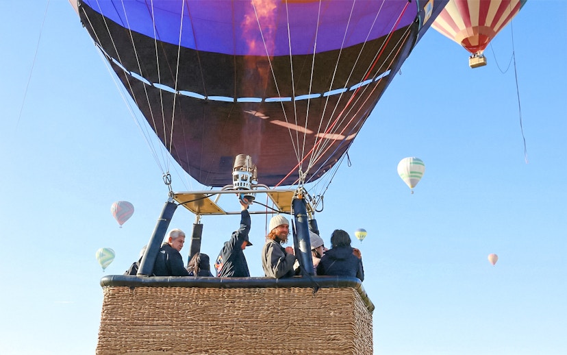 Hot air balloon flight over Teotihuacán with passengers in basket.