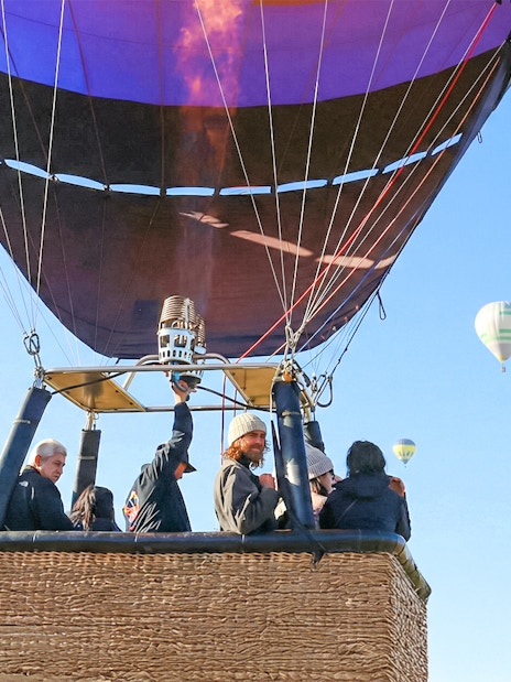 Hot air balloon flight over Teotihuacán with passengers in basket.
